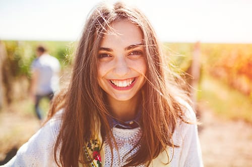 young woman smiling about the cosmetic dentistry that saved her smile